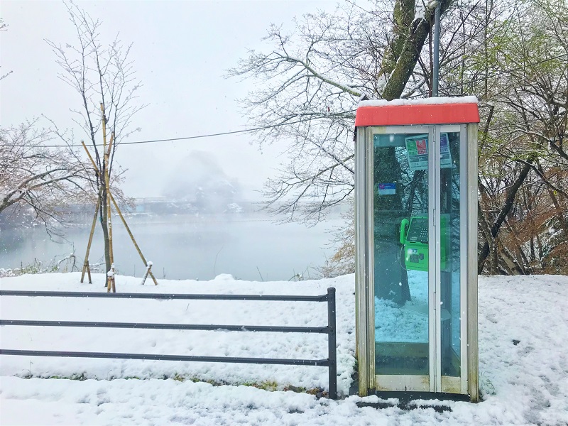 雪が降り積もる無人の電話ボックスの風景の無料写真